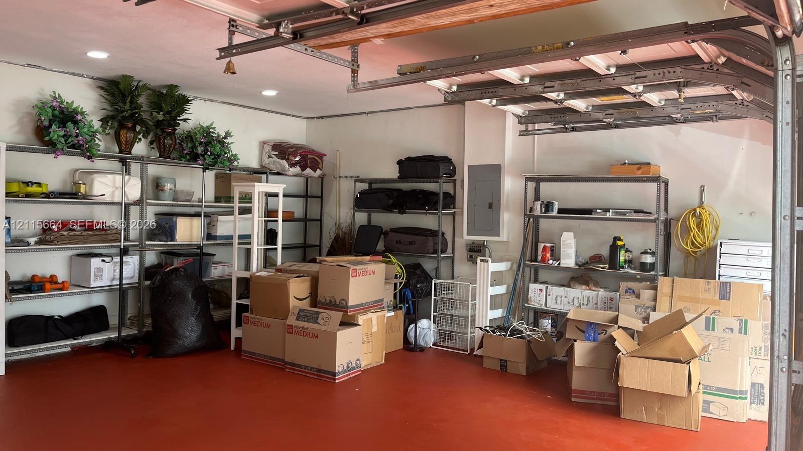 Garage featuring durable painted flooring, recessed lighting, and an electrical service panel