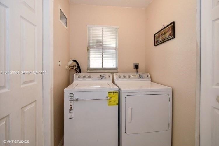 Laundry area featuring dual panel doors and a central window with horizontal blinds
