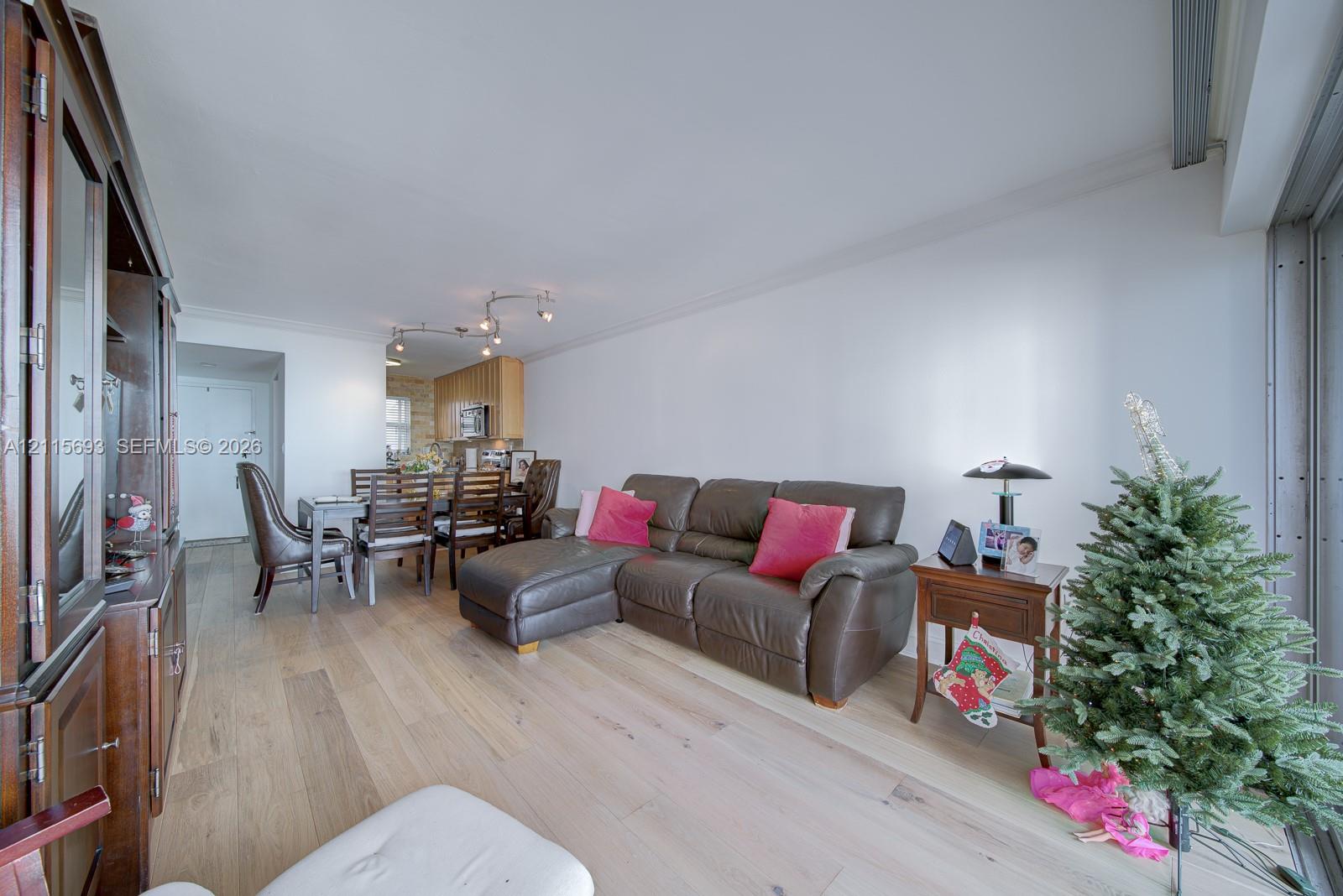 Light wood-finish flooring, recessed track lighting, and built-in wood cabinetry