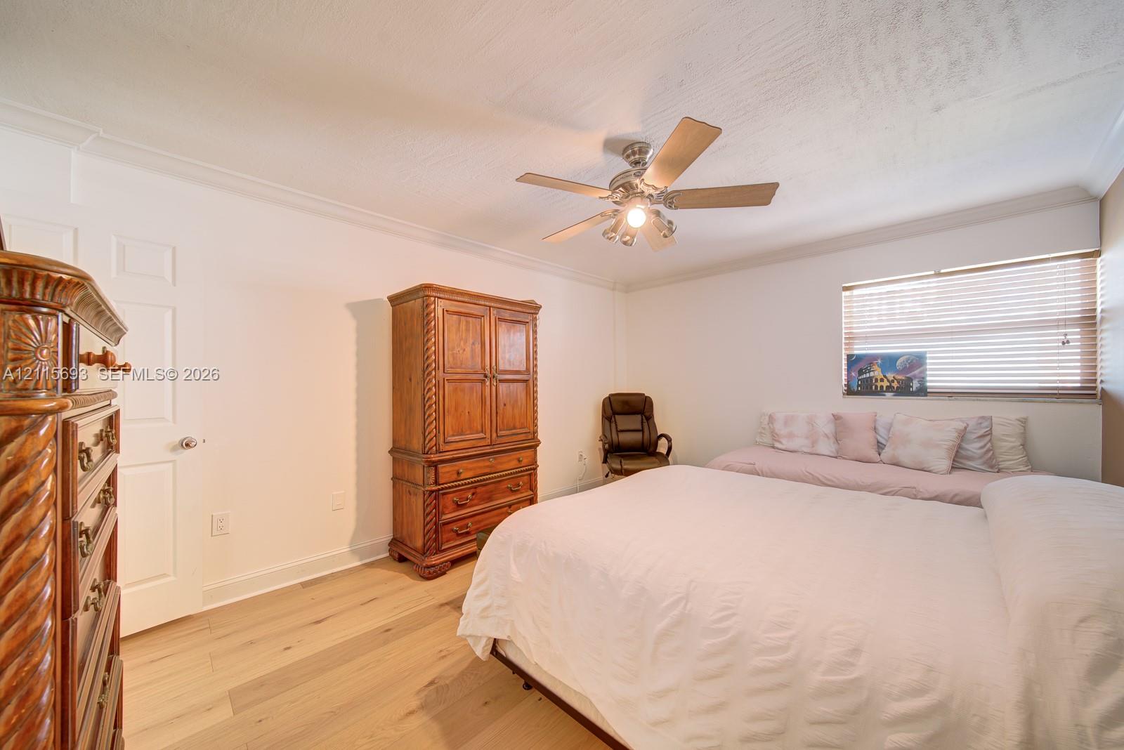 Wood-finish flooring, ceiling fan with integrated lighting, and horizontal window blinds