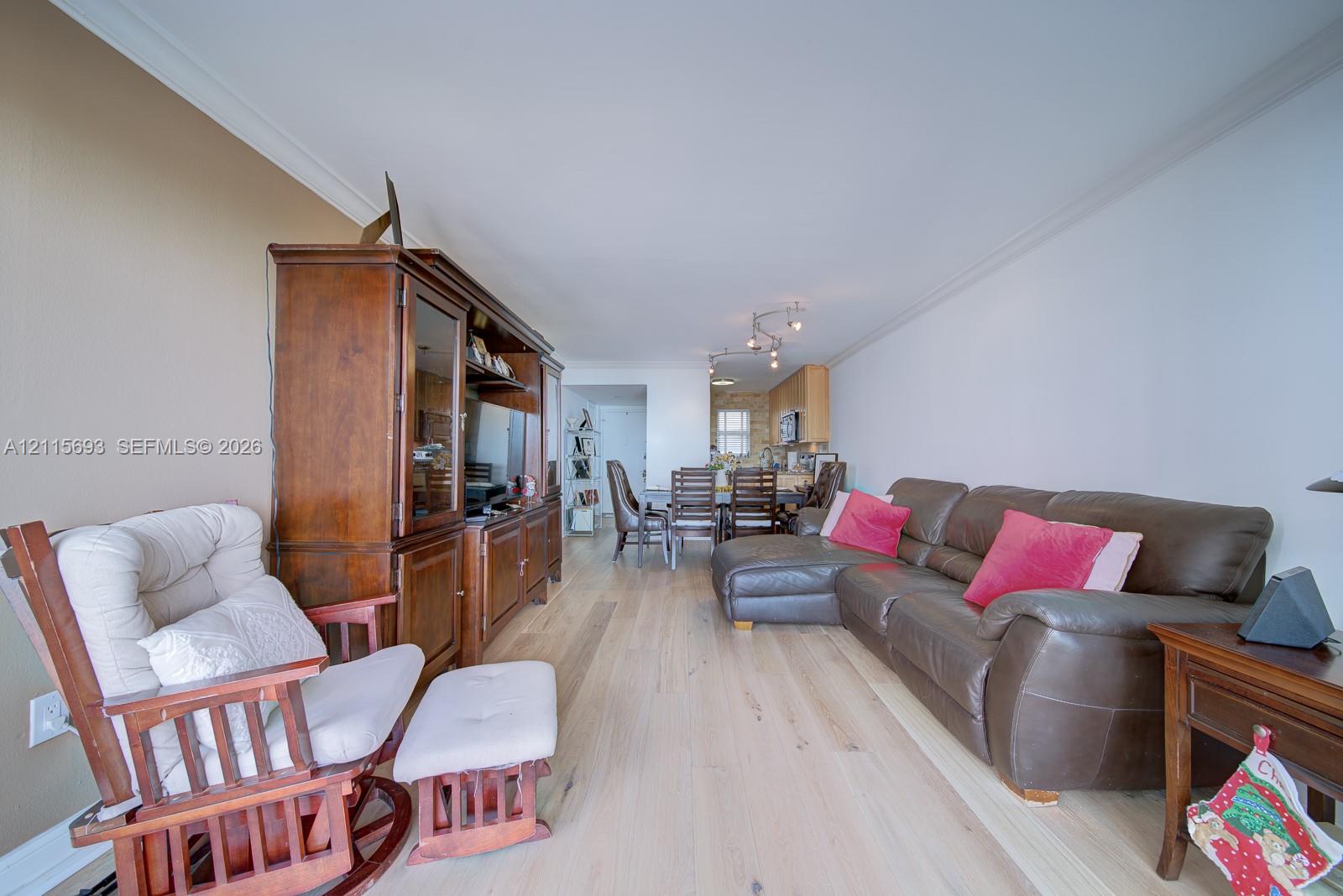 Living area featuring light-toned wood-finish flooring, neutral wall paint, and multi-light track ceiling fixtures