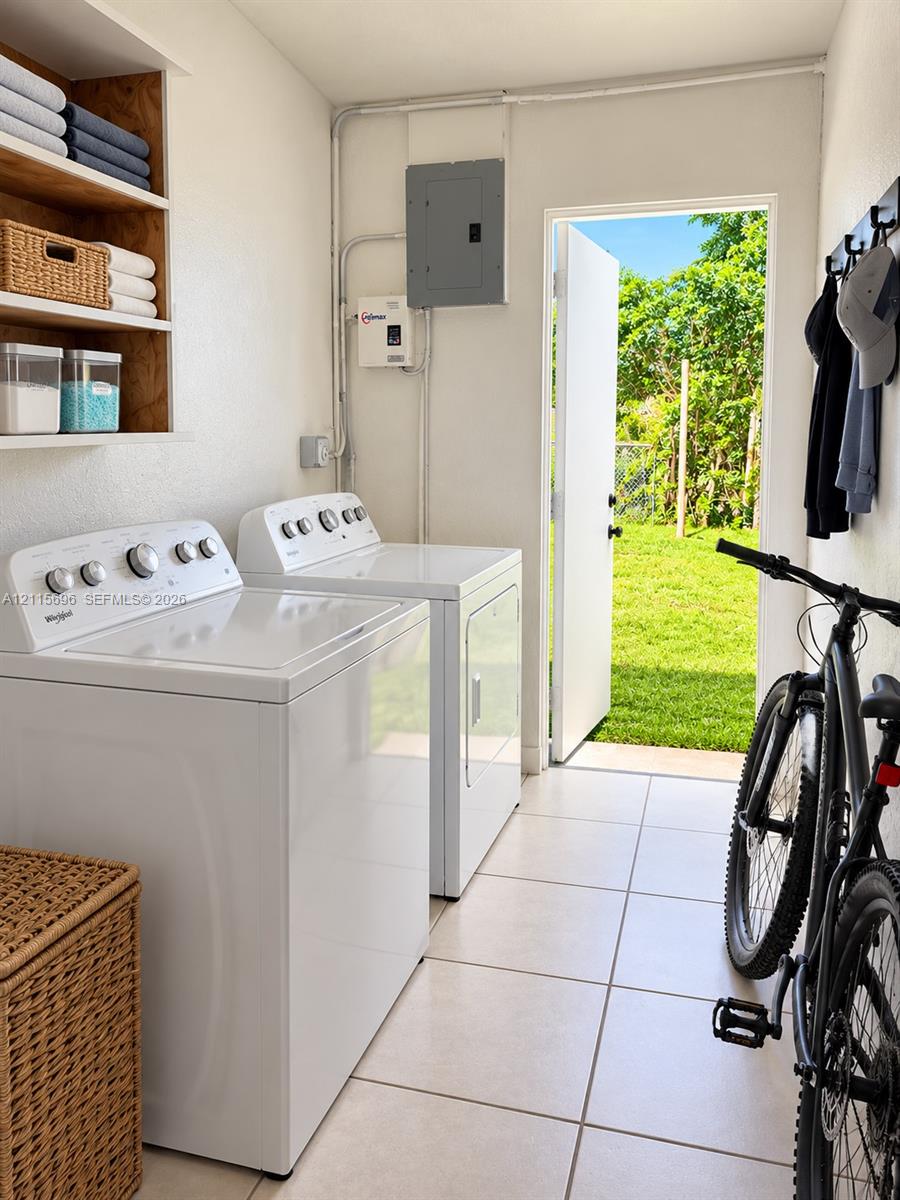 Laundry area featuring built-in wooden shelving, ceramic tile flooring, and direct exterior access to a grass lawn