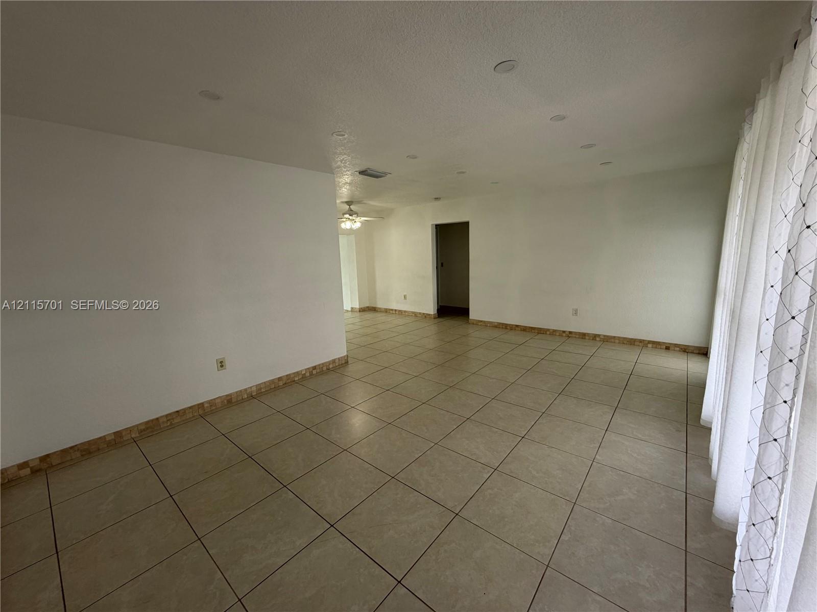Neutral-toned ceramic tile flooring, recessed ceiling lighting, and decorative mosaic tile trim Neutral-toned ceramic tile flooring, recessed ceiling lighting, and decorative mosaic tile trim