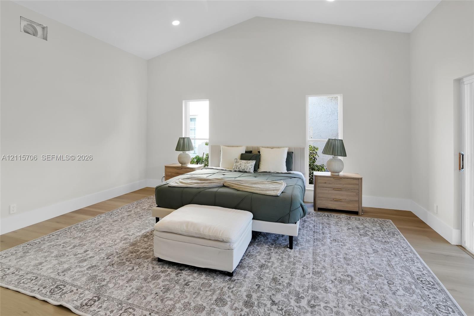 Vaulted ceilings featuring recessed lighting, neutral wall palette, and wood-finish flooring