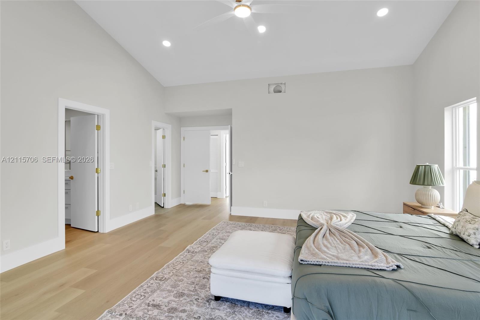 Vaulted ceilings, wood-finish flooring, recessed lighting, and a ceiling fan