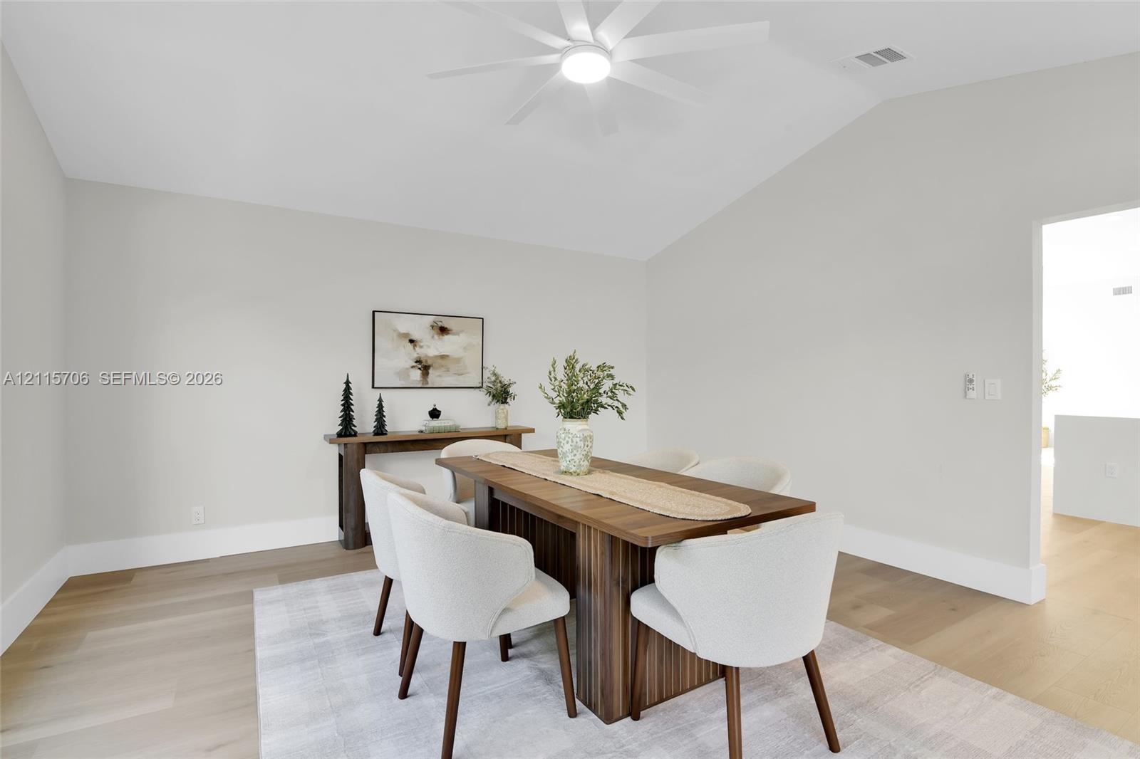 Vaulted ceilings, wood-finish flooring, and a modern ceiling fan with integrated lighting