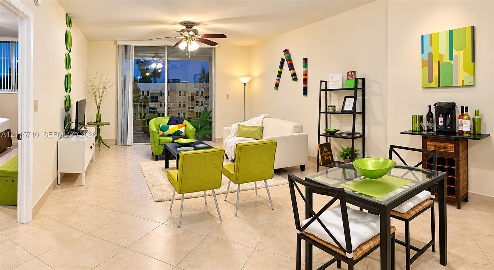 Living area featuring large-format ceramic tile flooring, a ceiling fan with integrated lighting, and a sliding glass door providing external access