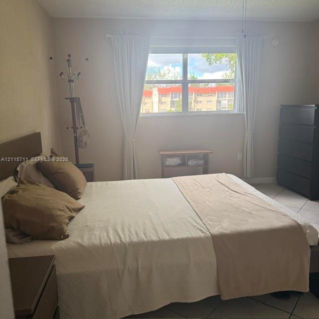 Neutral-toned interior room featuring tile flooring, a dual-pane horizontal sliding window, and a ceiling-mounted fan fixture