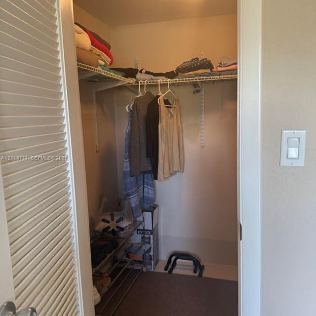 Storage closet featuring wire shelving and a louvered door
