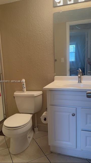 White vanity cabinet featuring a solid surface countertop, integrated sink, chrome-finish faucet, and a wall-mounted rectangular mirror
