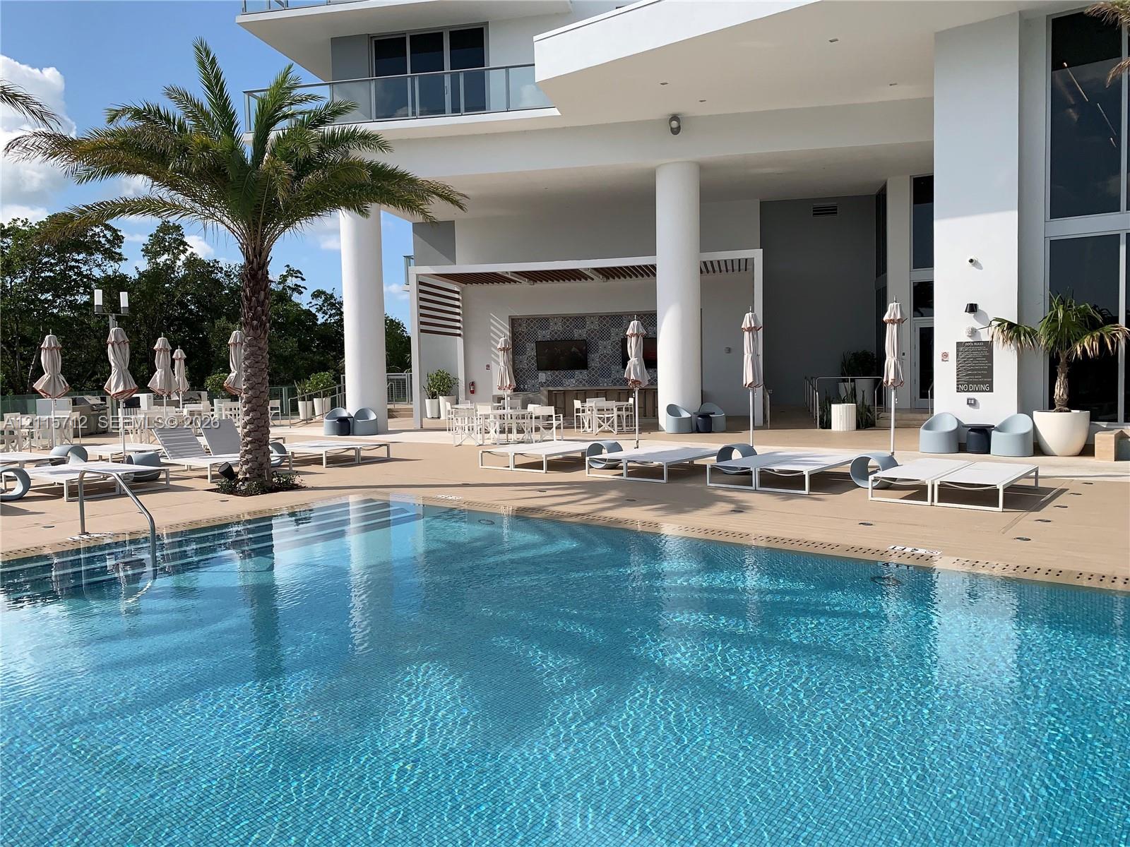 Swimming pool with integrated entry steps and expansive paved decking