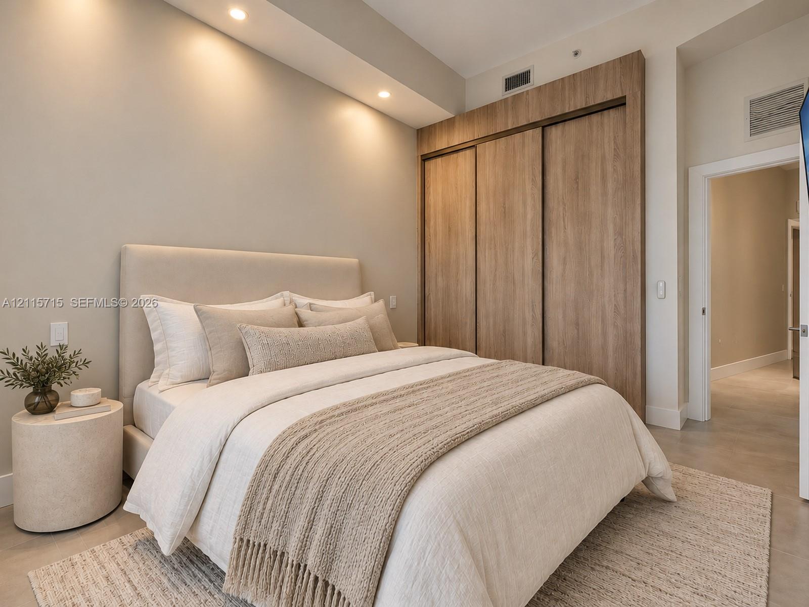 Built-in floor-to-ceiling wood-finish closet system, recessed ceiling lighting, and smooth-finish concrete flooring