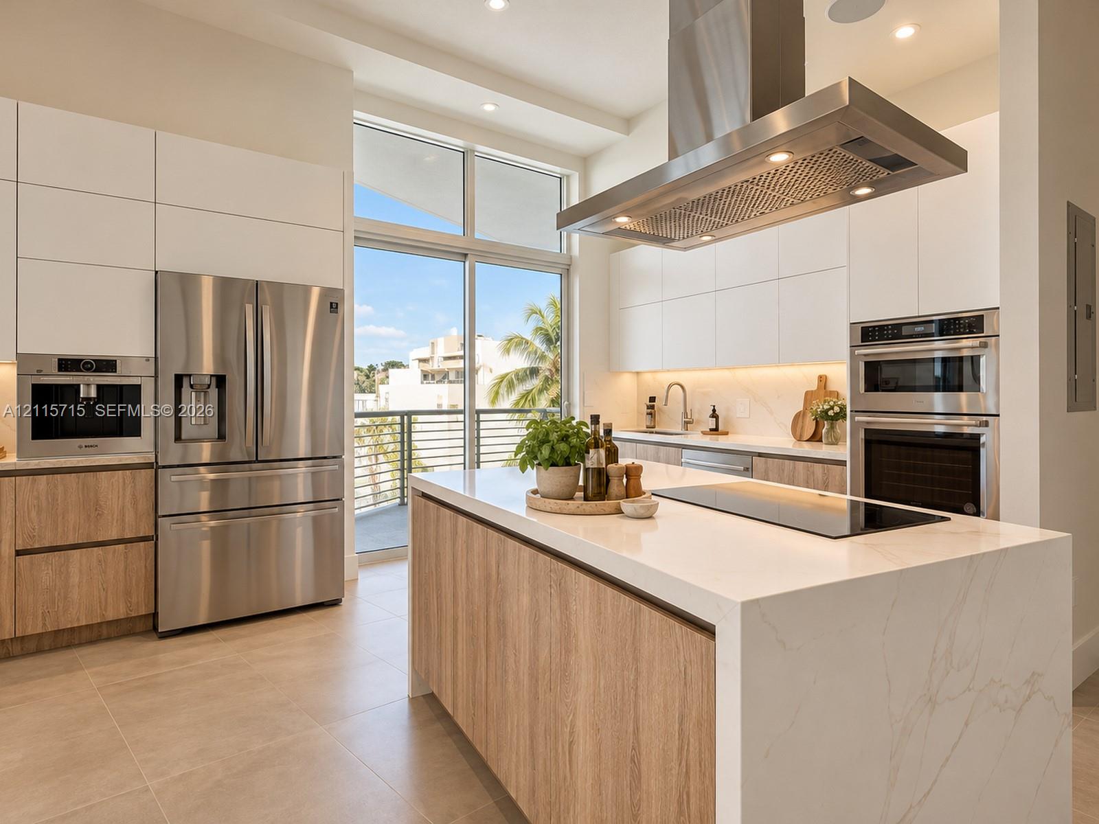 Kitchen featuring a waterfall-edge stone island, built-in stainless steel appliances, flat-panel cabinetry, a stainless steel chimney range hood, and floor-to-ceiling glass sliding doors
