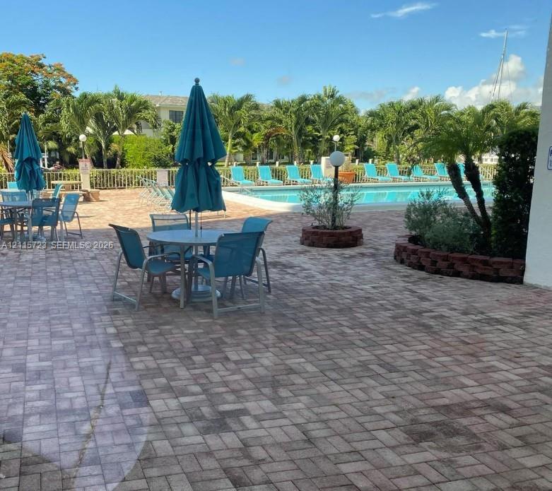 Swimming pool area with brick paver decking, raised masonry planter beds, and metal perimeter fencing Swimming pool area with brick paver decking, raised masonry planter beds, and metal perimeter fencing