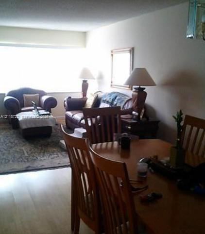 Large window with expansive natural light, wood-finish flooring, and neutral wall tones