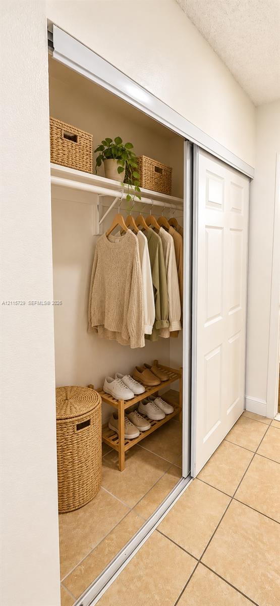 Closet featuring sliding multi-panel doors, upper shelving, and a horizontal hanging rod
