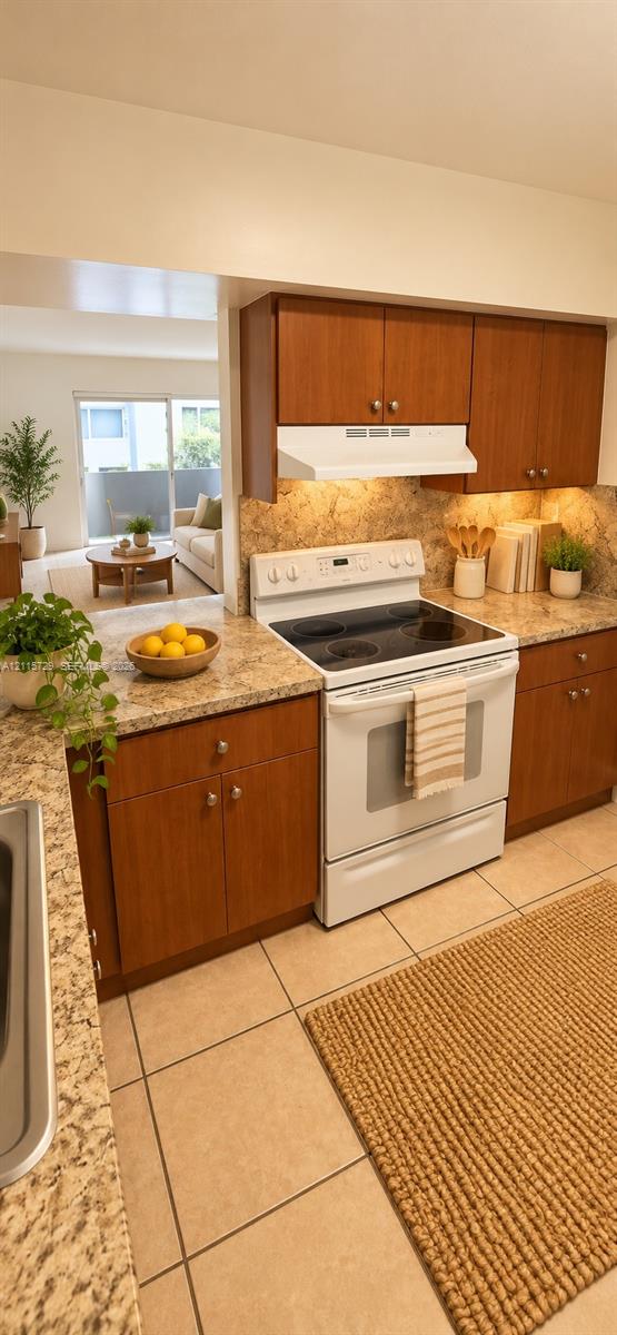 Kitchen featuring wood cabinetry, solid surface countertops, a white electric range, and ceramic tile flooring