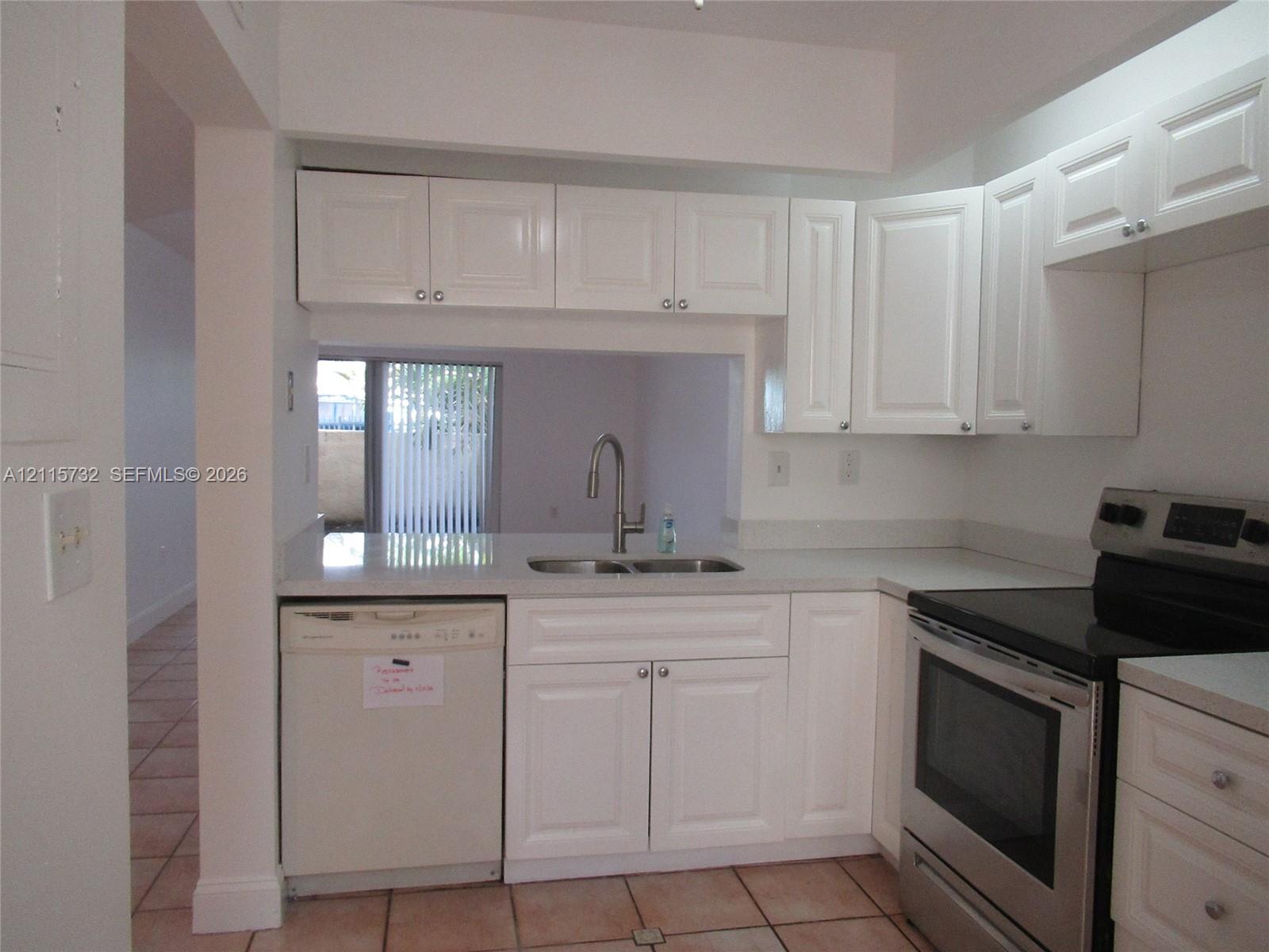 Kitchen featuring white cabinetry, stainless steel oven, integrated dishwasher, solid surface countertops, and an undermount sink with a gooseneck faucet Kitchen featuring white cabinetry, stainless steel oven, integrated dishwasher, solid surface countertops, and an undermount sink with a gooseneck faucet