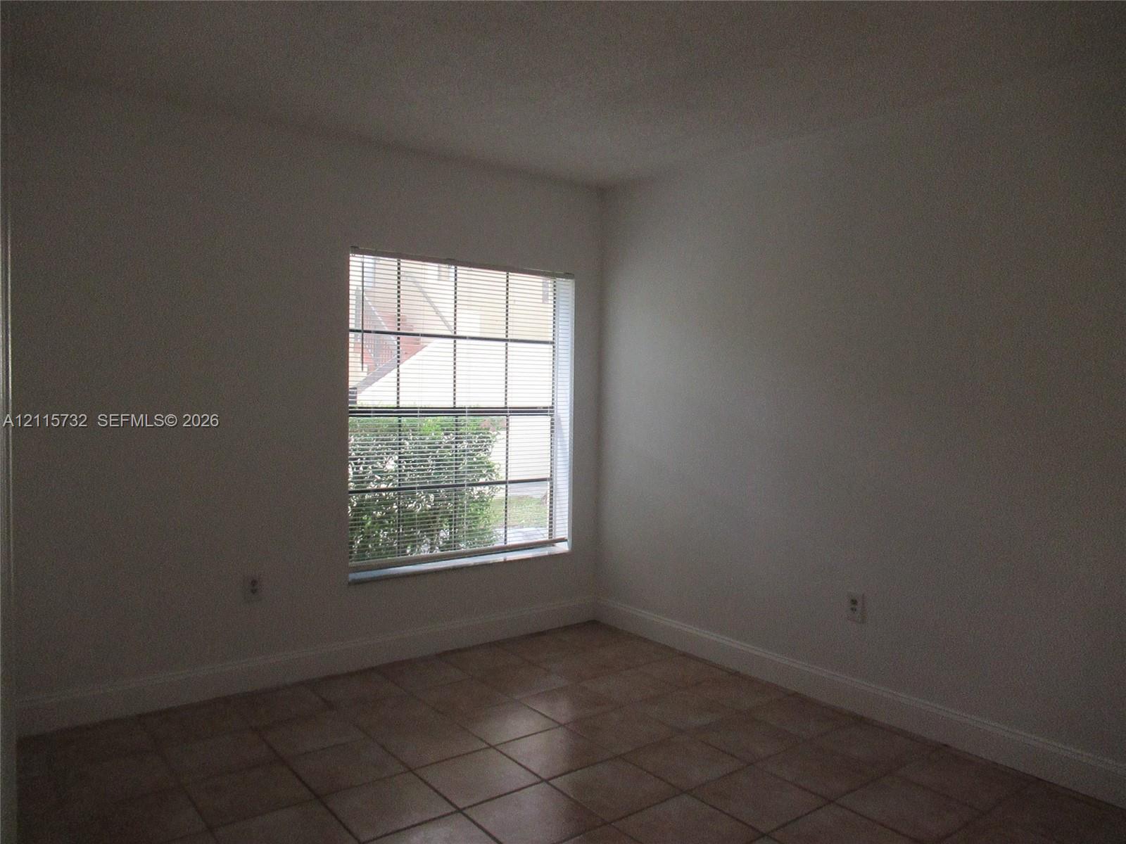 Interior room featuring neutral wall finishes, tile flooring, and a single-pane window with grid detailing