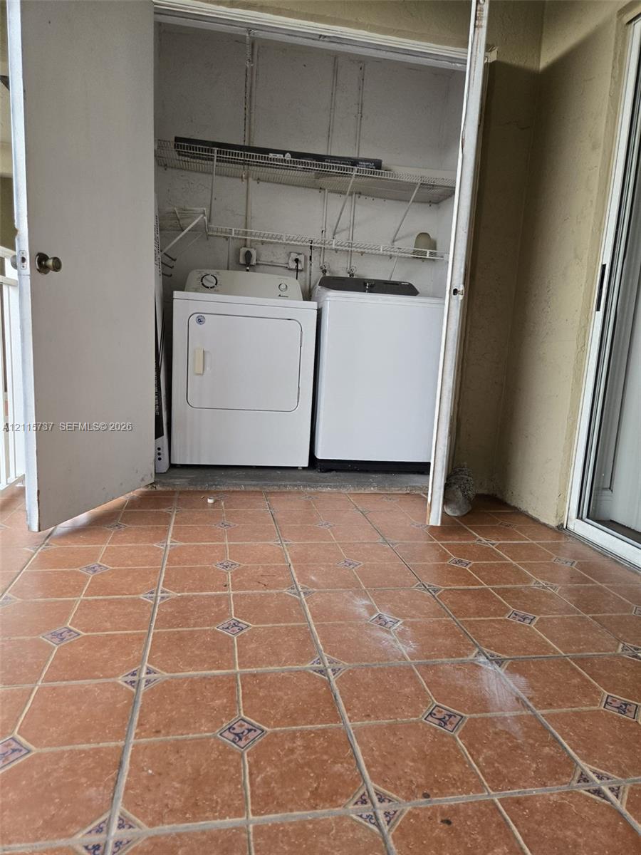Laundry closet featuring built-in wire shelving and ceramic tile flooring