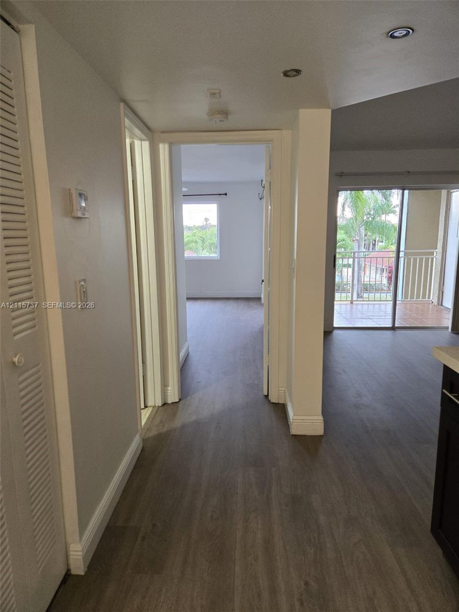 Wood-finish flooring, recessed lighting, louvered bi-fold closet doors, and sliding glass patio door