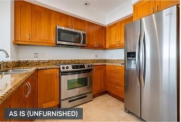 Kitchen featuring natural wood cabinetry, stone-surface countertops, stone-tile backsplash, and integrated stainless steel appliances