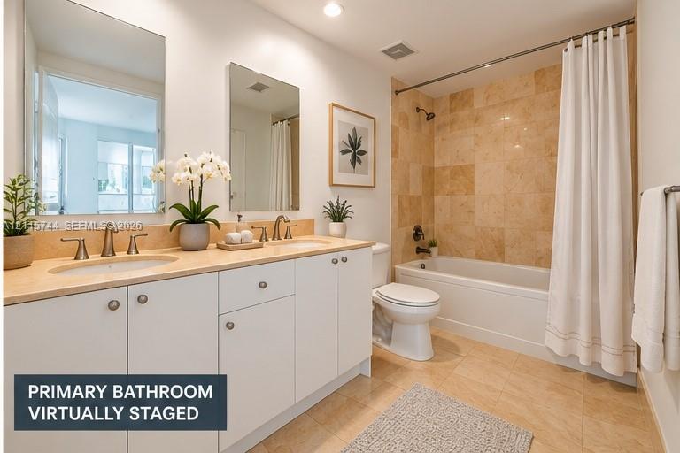 Dual-sink vanity with light-toned countertop, stone-tile tub surround, and tile flooring
