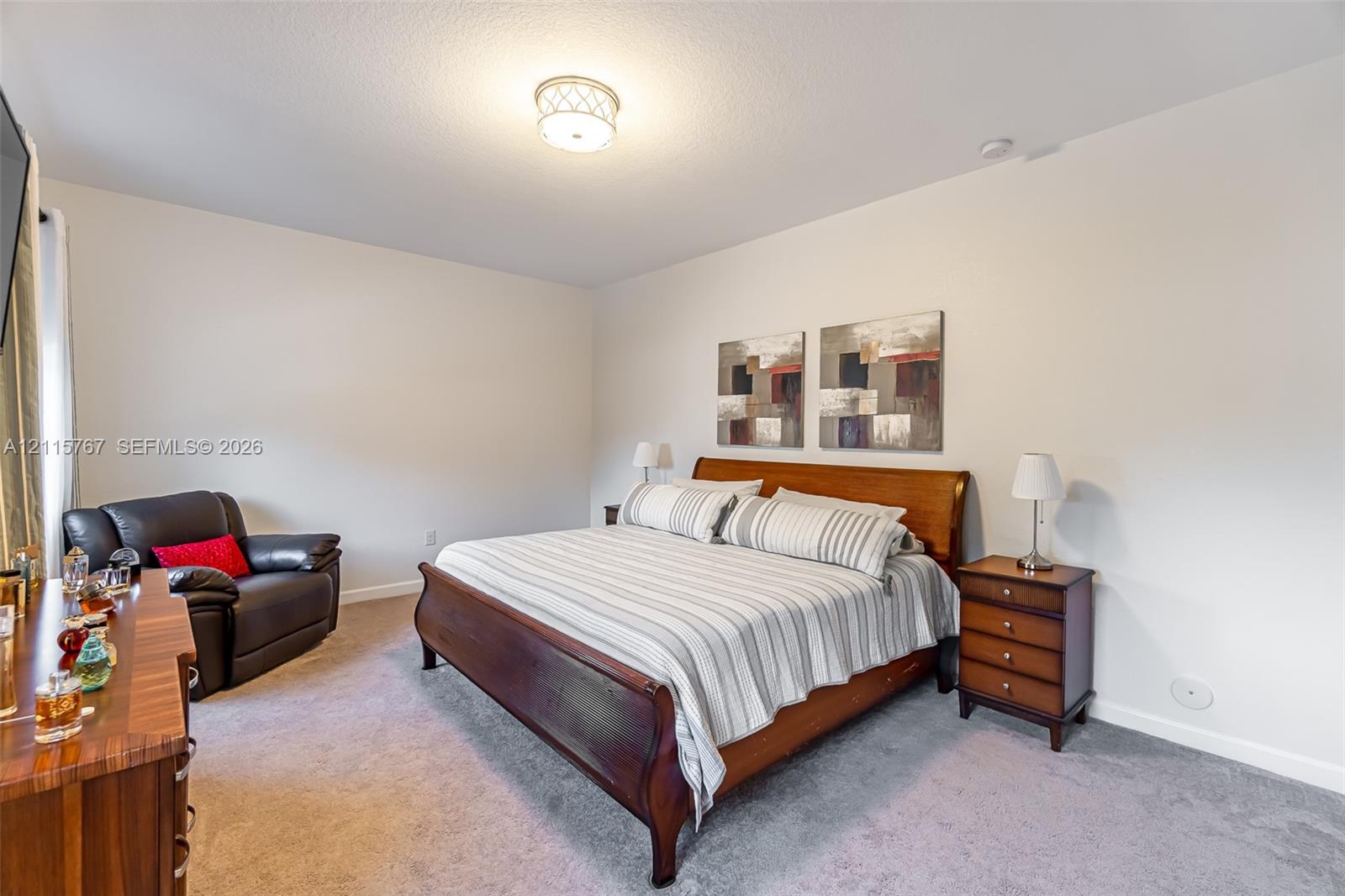 Neutral wall paint, plush carpeting, and a polished drum-style ceiling light fixture