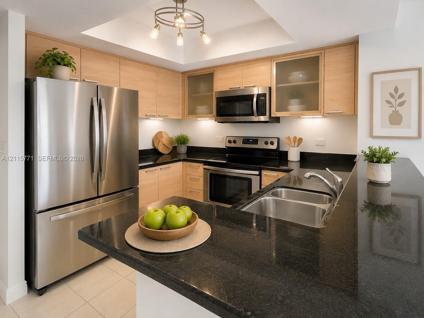 Kitchen featuring light wood-finish cabinetry, dark stone countertops, stainless steel appliances, a double-basin under-mount sink, and recessed ceiling lighting
