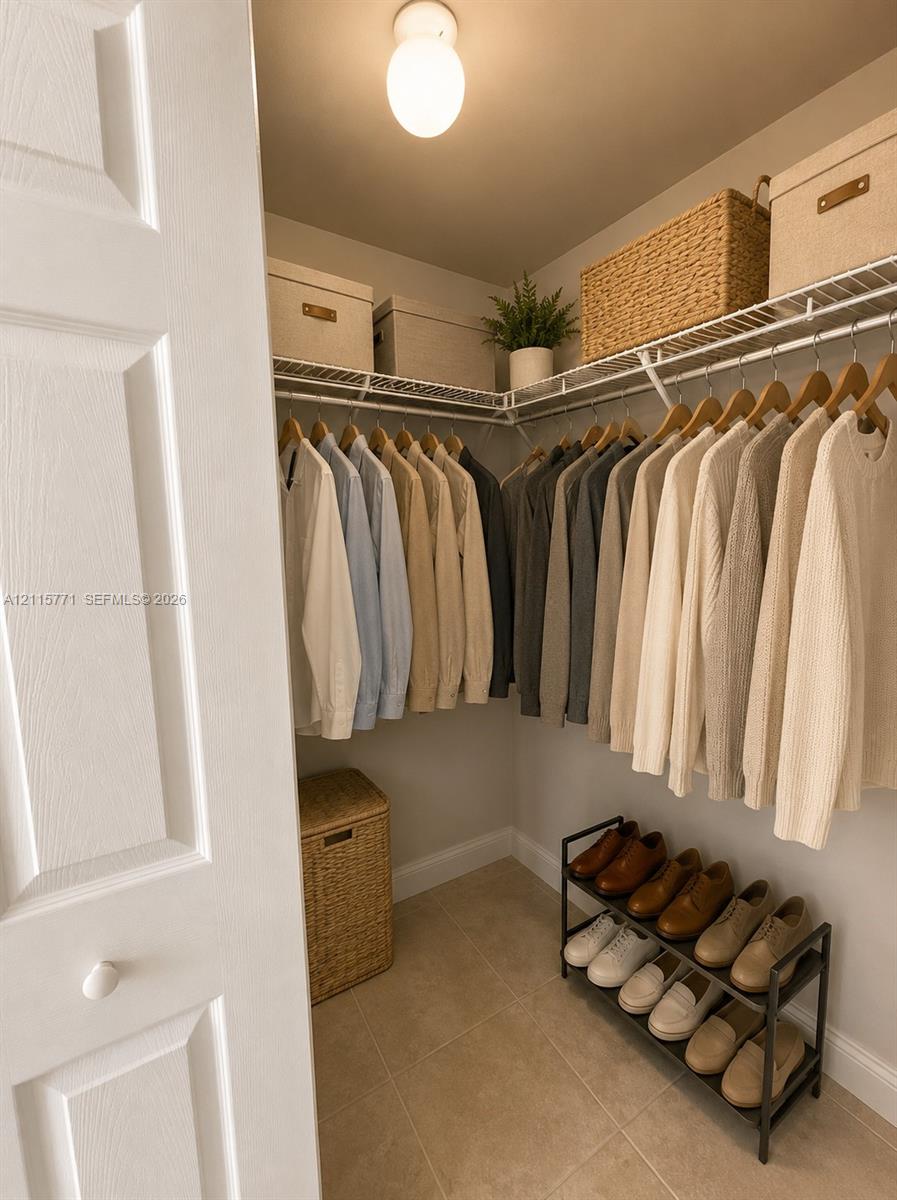 Walk-in closet featuring ceramic tile flooring, tiered wire shelving, and a spherical flush-mount ceiling light