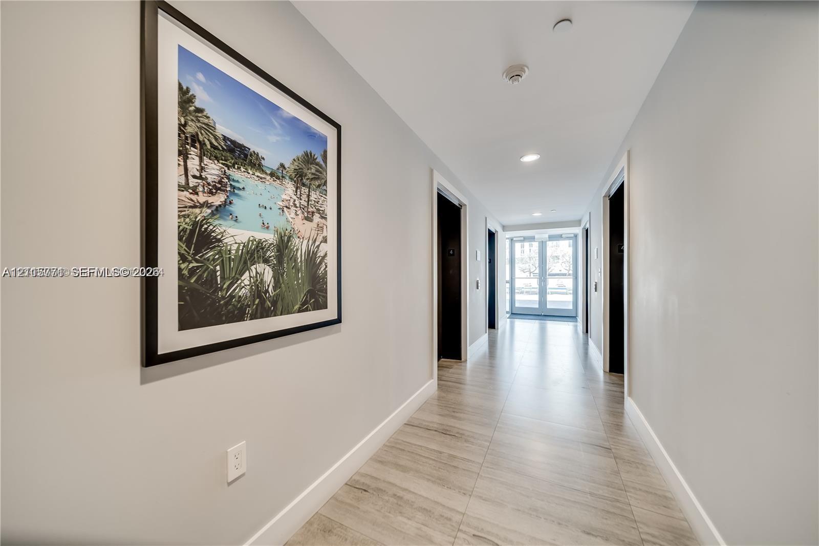 Hallway featuring wood-finish tile flooring, recessed ceiling lighting, and neutral wall tones