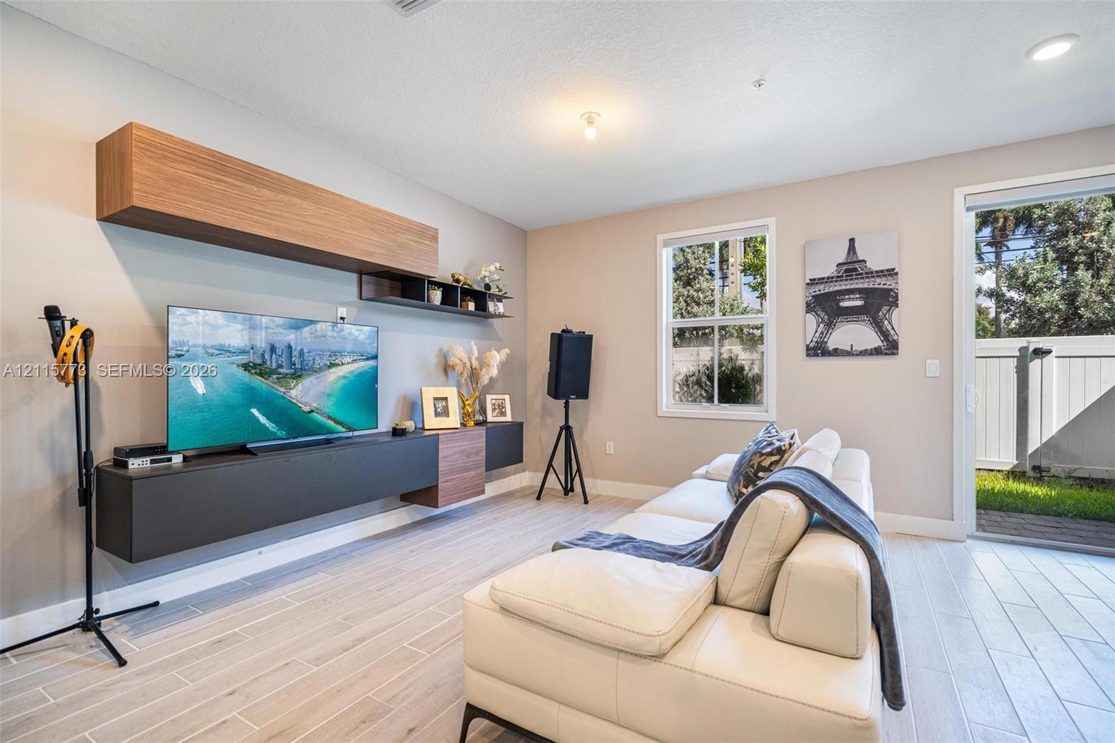 Living space featuring wood-finish tile flooring, built-in dual-tone wall cabinetry, and glass sliding door access to exterior space