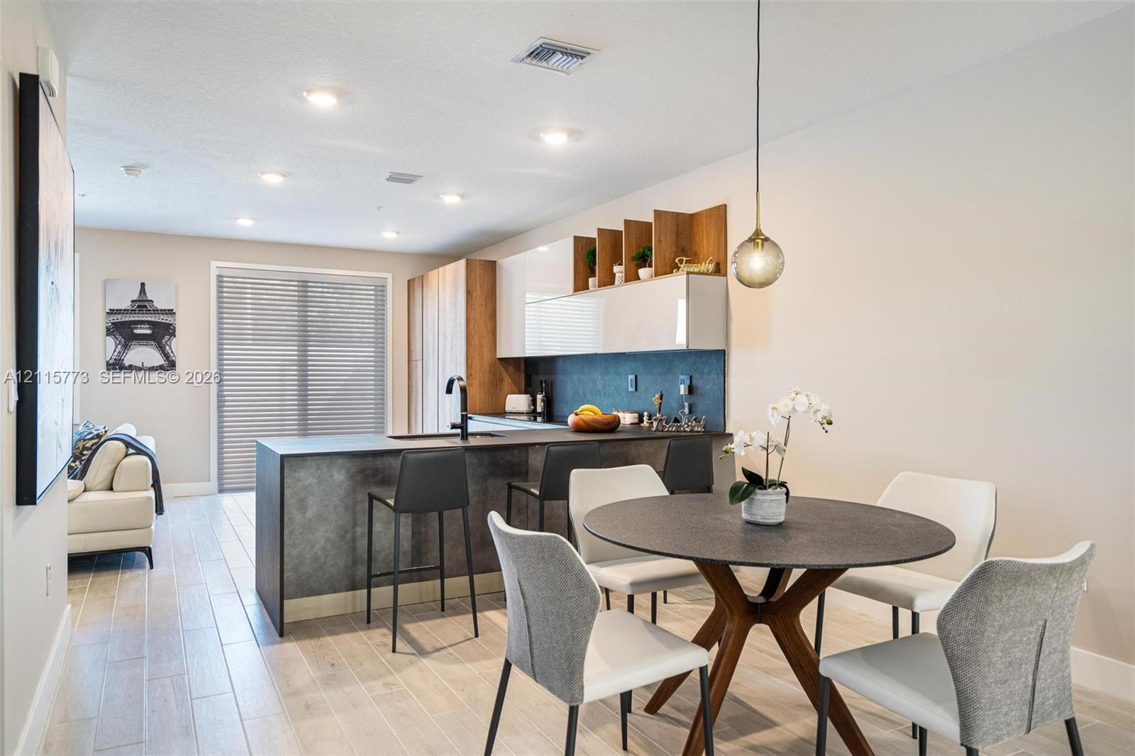 Kitchen featuring two-tone cabinetry with wood-finish shelving, stone-finish countertops, matte black plumbing fixtures, recessed ceiling lighting, and wood-finish flooring