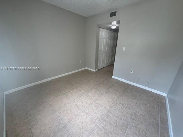 Neutral-toned interior space featuring ceramic tile flooring and a double-panel closet with white doors