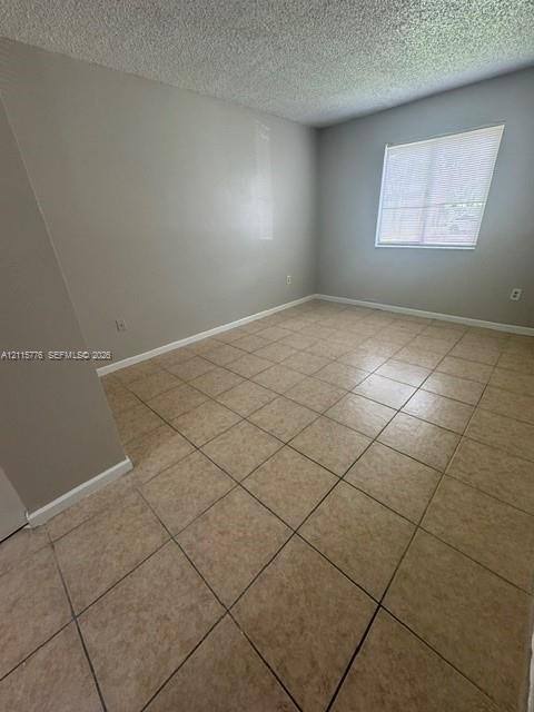 Interior space featuring neutral-toned walls, square-tiled flooring, and a single-pane window with installed blinds
