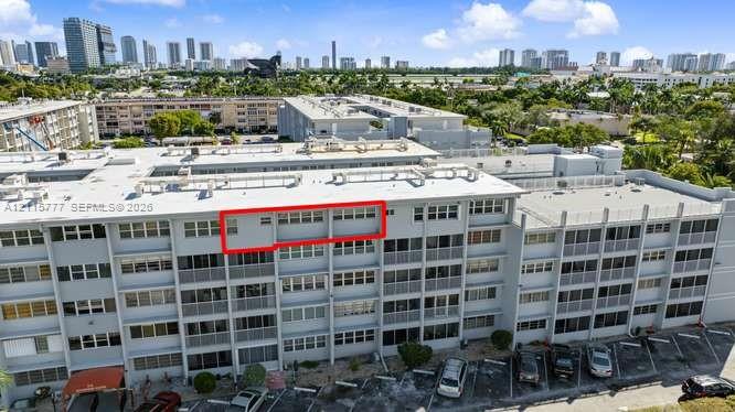Multi-story residential building exterior featuring horizontal rows of windows, concrete structural framing, and private balcony spaces