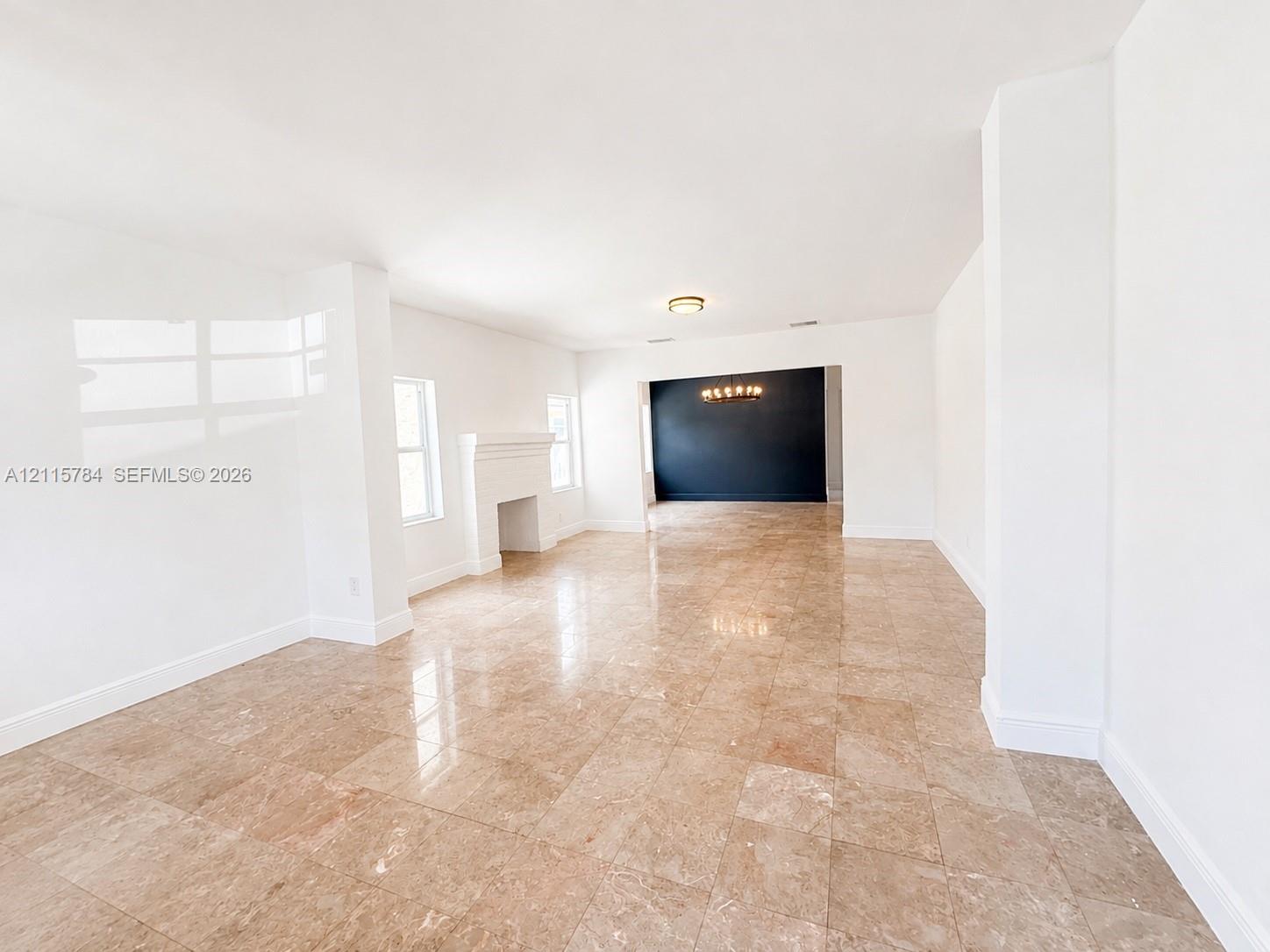 Polished stone flooring, fireplace with an architectural mantle, recessed lighting, and a contrasting feature wall