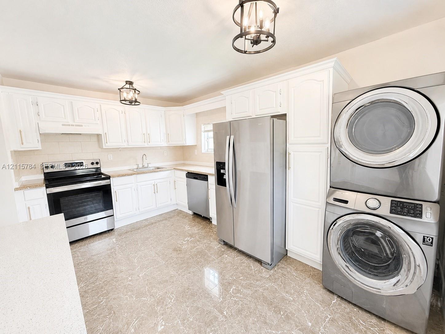 Kitchen featuring white cabinetry, stone-finish countertops, stainless steel appliances, stone-look tile flooring, and decorative lantern-style pendant lighting