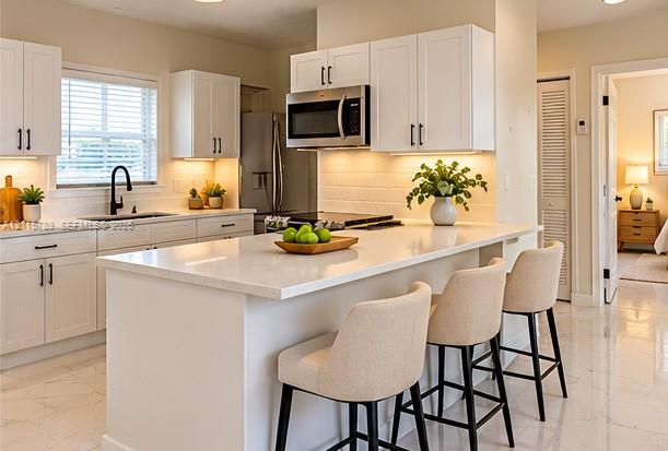 Kitchen featuring white cabinetry, an expansive center island with quartz-style countertops, stainless steel appliances, a tile backsplash, and polished tile flooring