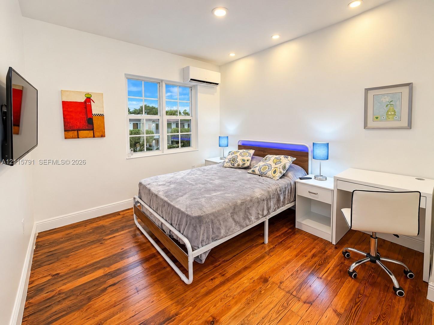 Wood-finish flooring, recessed lighting, wall-mounted ductless climate control unit, and multi-pane window