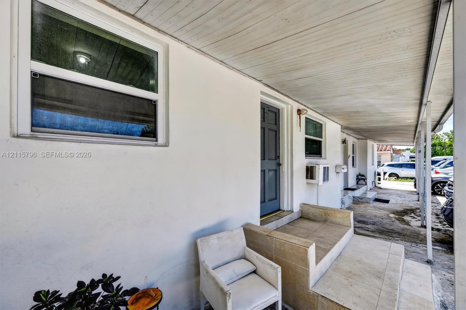 Covered entryway featuring a smooth stucco exterior, tiled steps, and a paneled entry door