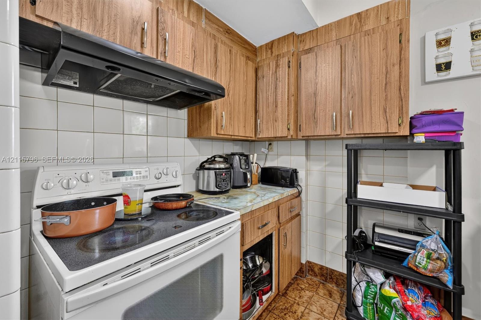 Kitchen featuring wood-finish cabinetry, a square-tiled backsplash, and stone-finish countertops