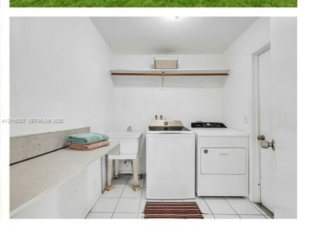 Laundry space featuring ceramic tile flooring, a utility sink with a faucet, a solid-surface folding counter, and a built-in wall-mounted shelf with a hanging rod