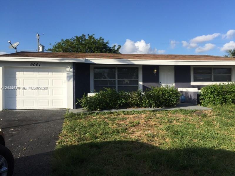 Single-story residence featuring an attached garage, horizontal sliding windows, and a paved driveway