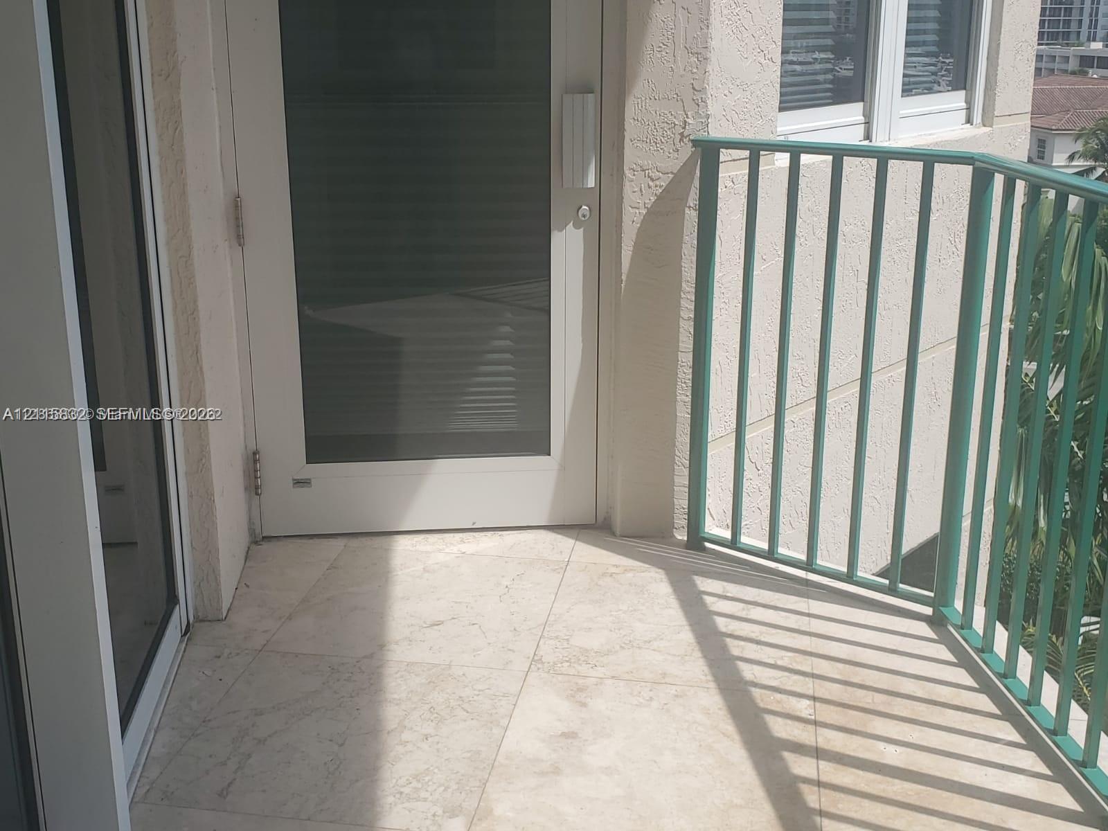 Balcony featuring light-toned stone-finish flooring and a metal railing