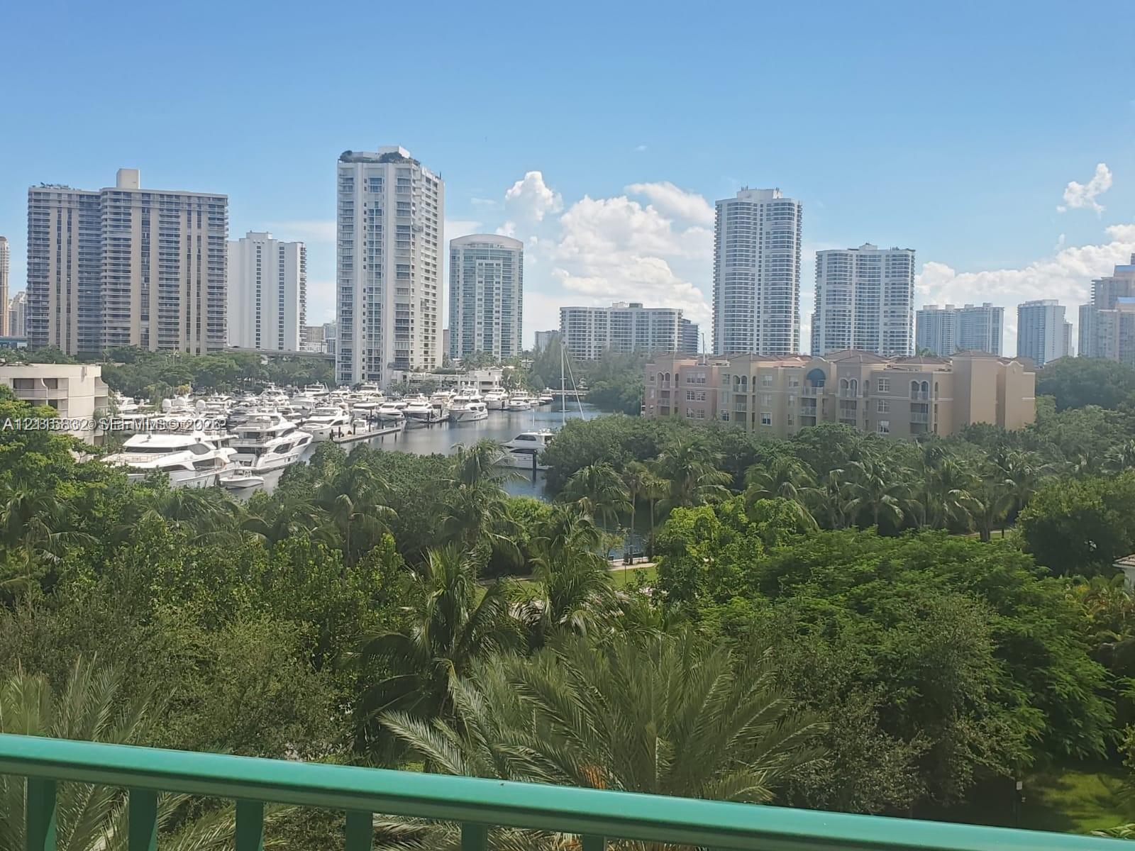 Expansive urban skyline backdrop with waterway access, marina with boat slips, and dense canopy of mature trees Expansive urban skyline backdrop with waterway access, marina with boat slips, and dense canopy of mature trees