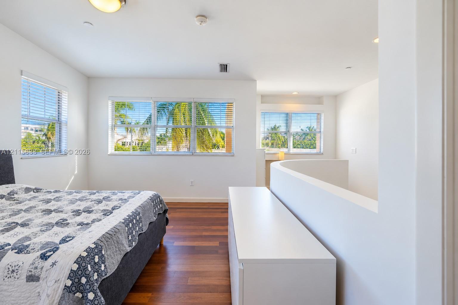 Wood-finish flooring, recessed lighting, multi-pane windows, and a curved half-wall architectural detail