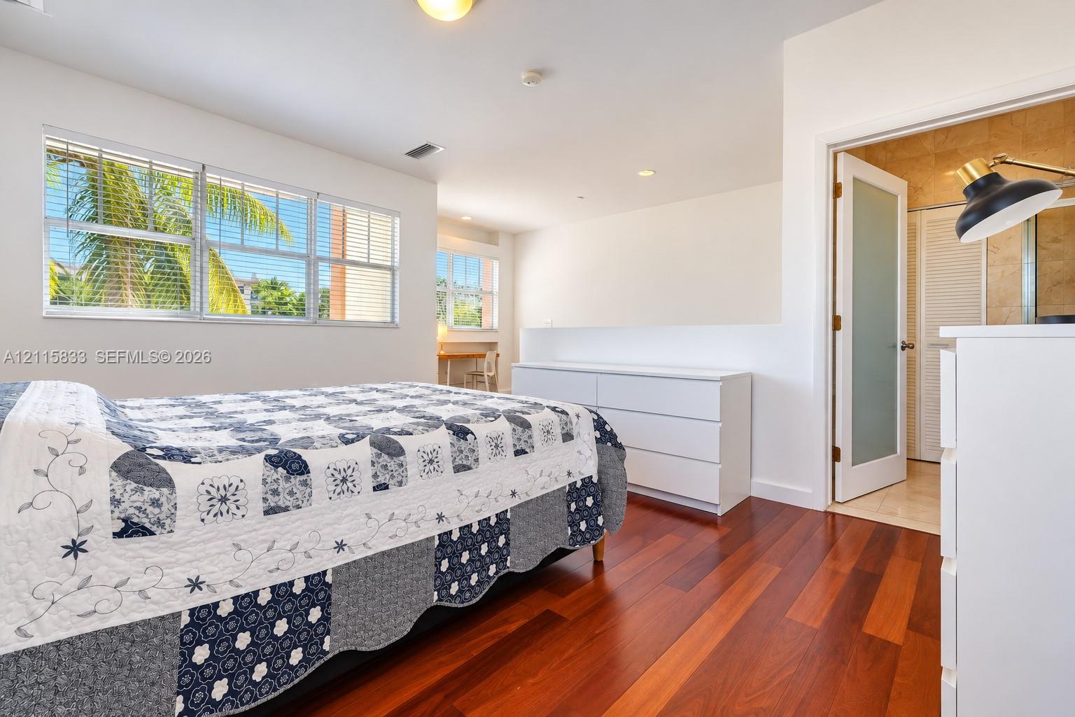 Wood-finish flooring, multi-pane windows, recessed lighting, and a frosted glass panel door