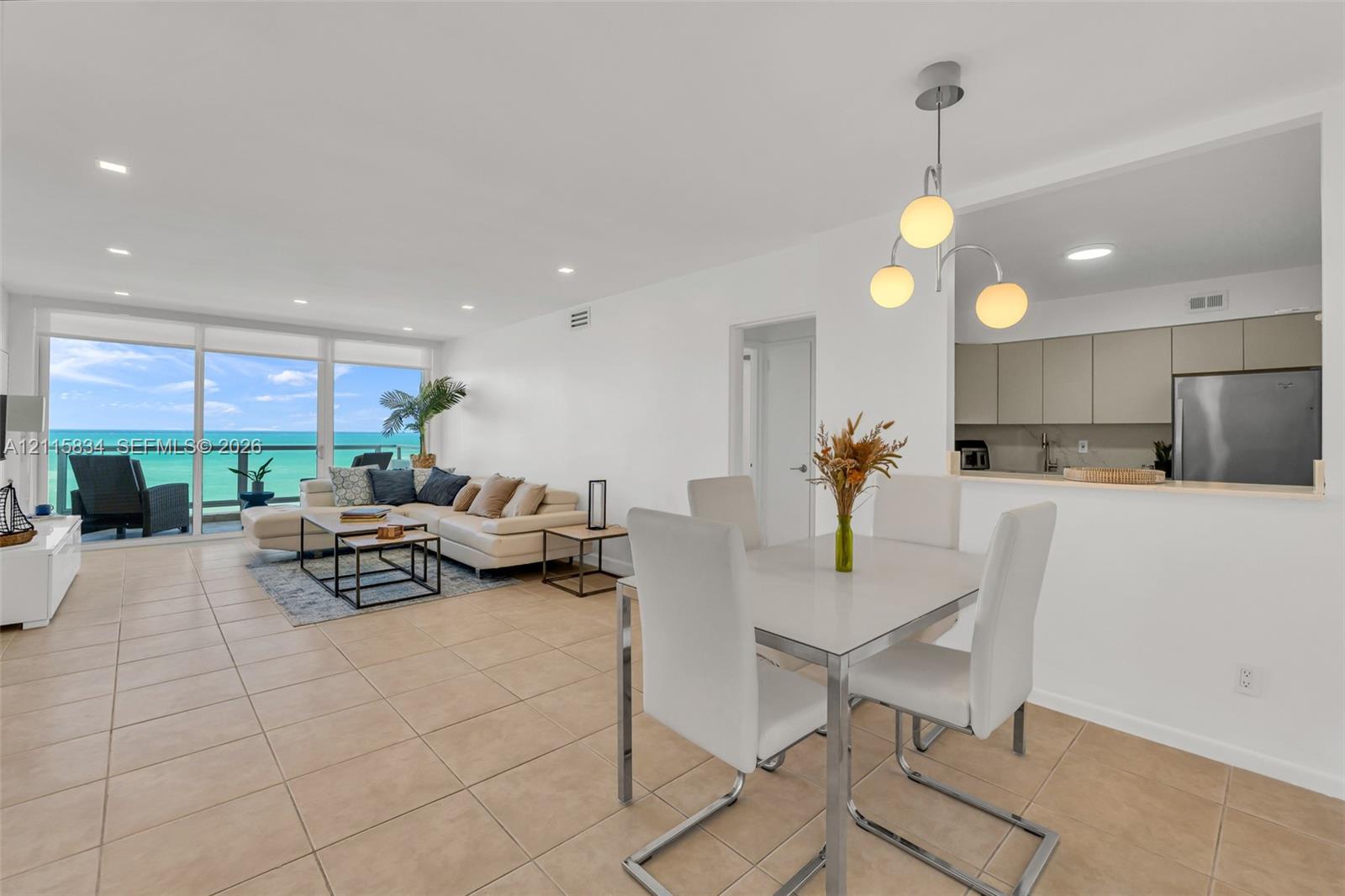 Open-concept interior featuring large-format tile flooring, floor-to-ceiling glass doors, and recessed lighting