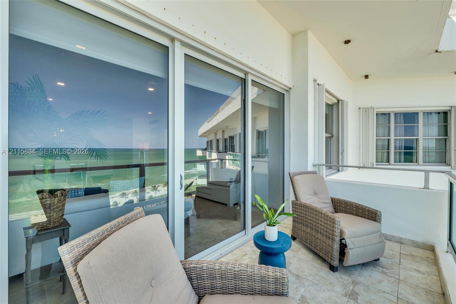 Covered balcony featuring tile flooring, metal railing, recessed ceiling lighting, and large sliding glass doors